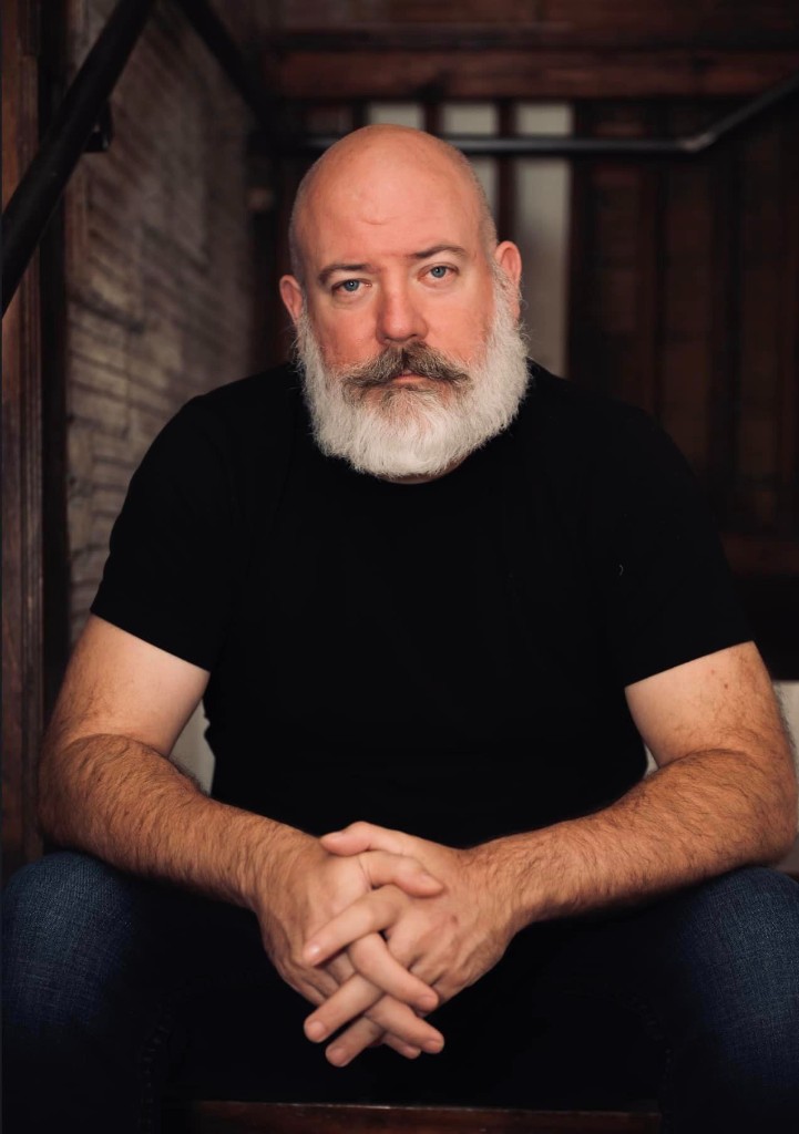 Ross Wright, seated, looking toward the camera